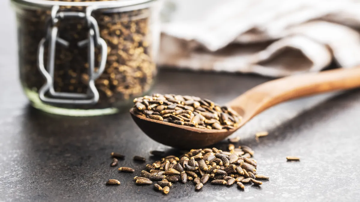 マリアアザミの種子とすり鉢のセットが並ぶ様子。インコの健康ケアのイメージを表現した画像。